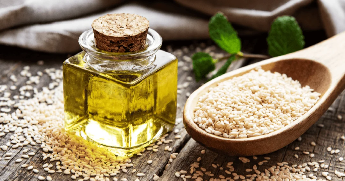 Frasco de aceite de sésamo junto a semillas de sésamo sobre una mesa rústica, representando el aroma tostado y la versatilidad del aceite de sésamo Roland en la cocina cotidiana.